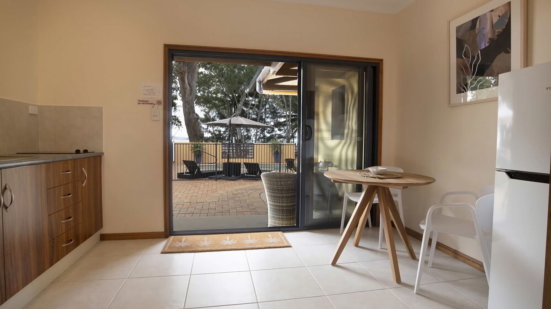 A kitchen with a sliding glass door leading to an outdoor patio area.