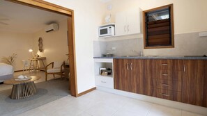 A modern kitchen with wooden cabinets, a microwave, and a window.