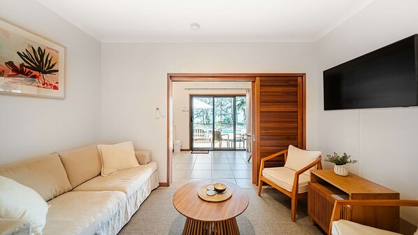 A modern living room with a sofa, a coffee table, and a TV.