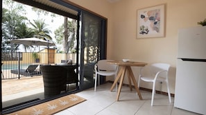 Eine moderne Küche mit Essbereich, einem Kühlschrank und Blick auf einen Pool sowie Sitzgelegenheiten im Freien.