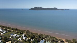 A coastal residential area with houses, a beach, and a clear view of the ocean.