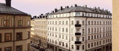 A corner building with a classical architectural style, featuring multiple stories and a symmetrical facade with evenly spaced windows and decorative elements.