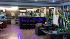 A modern bar area with a counter and seating. - Carliza Hotel Lekki (Lekki)