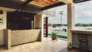 A reception area with a counter, wooden ceiling, and a view of the cityscape. - Hotel Yorio Inn (Tuxpan)