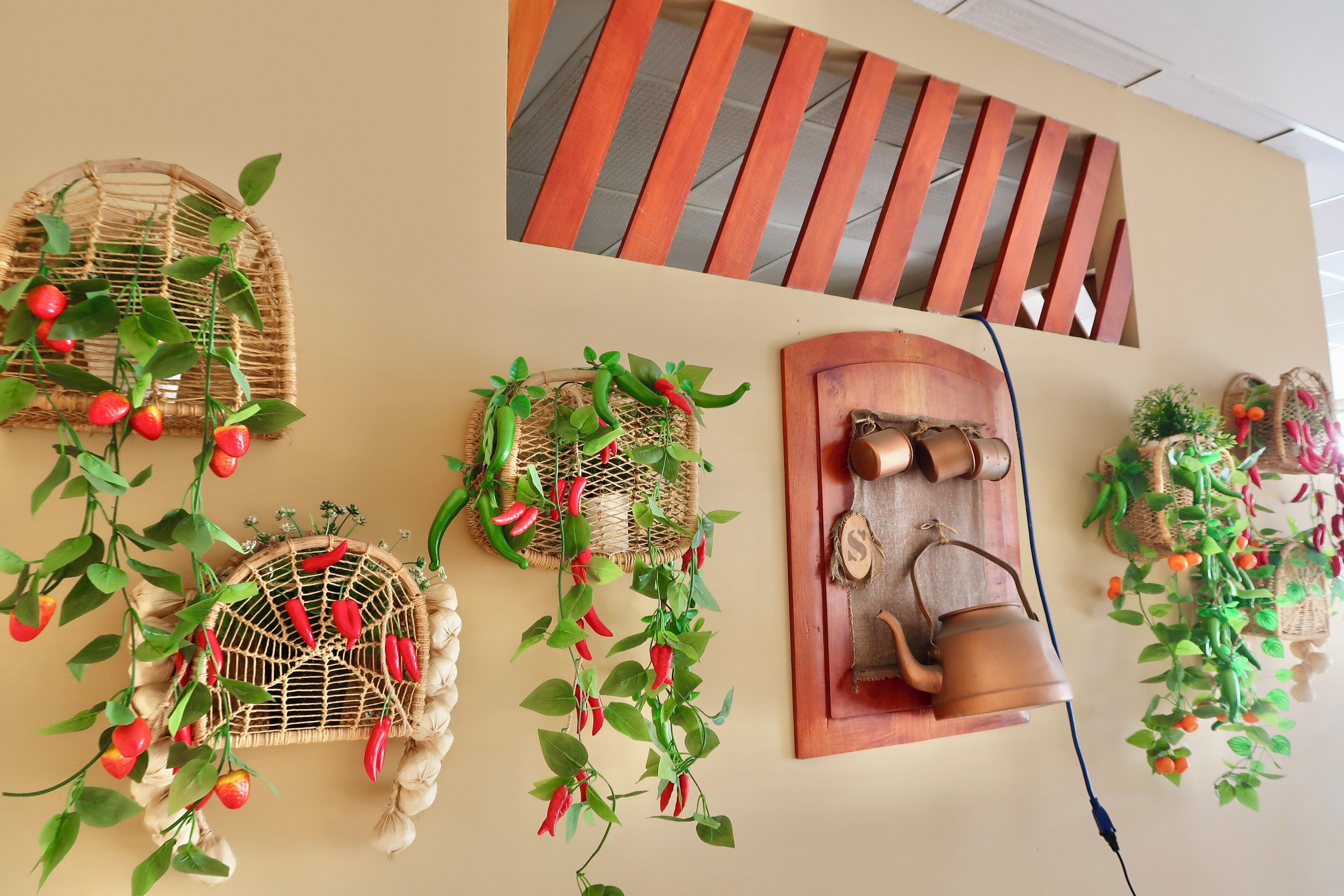 A wall with various decorative items including wicker baskets, wooden panels, and a copper kettle.