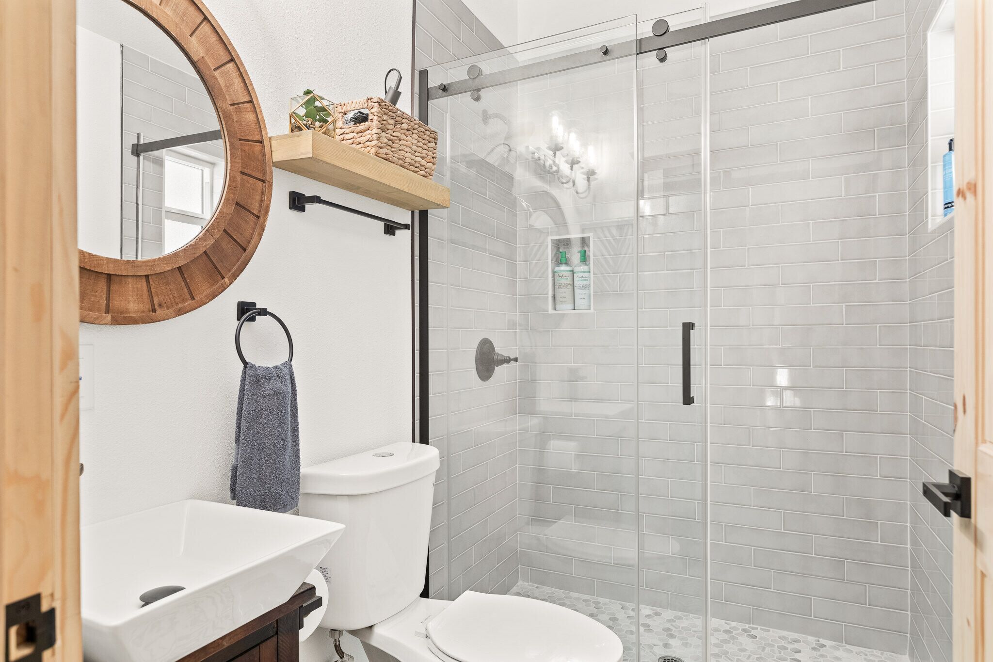 Een moderne badkamer met een wit wastafel, toilet en een douchecabine.