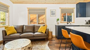 Eine moderne Küche mit dunklen Schränken, einer weißen Arbeitsplatte und einer Holzbalkendecke.