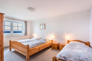 Une chambre à coucher avec un lit en bois, des tables de chevet, une fenêtre avec des stores et un tableau encadré au mur.