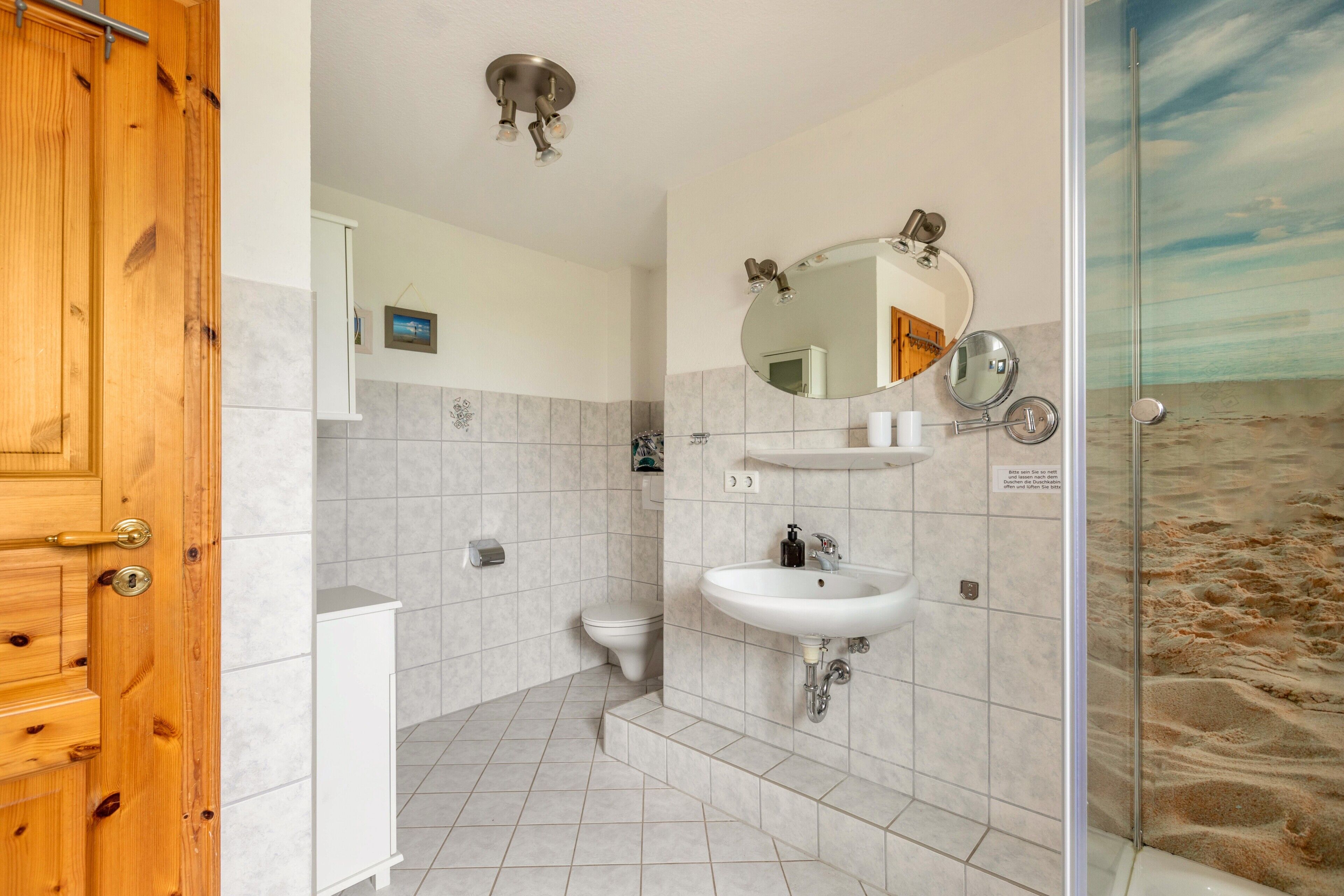 A bathroom with a shower, toilet, and sink.