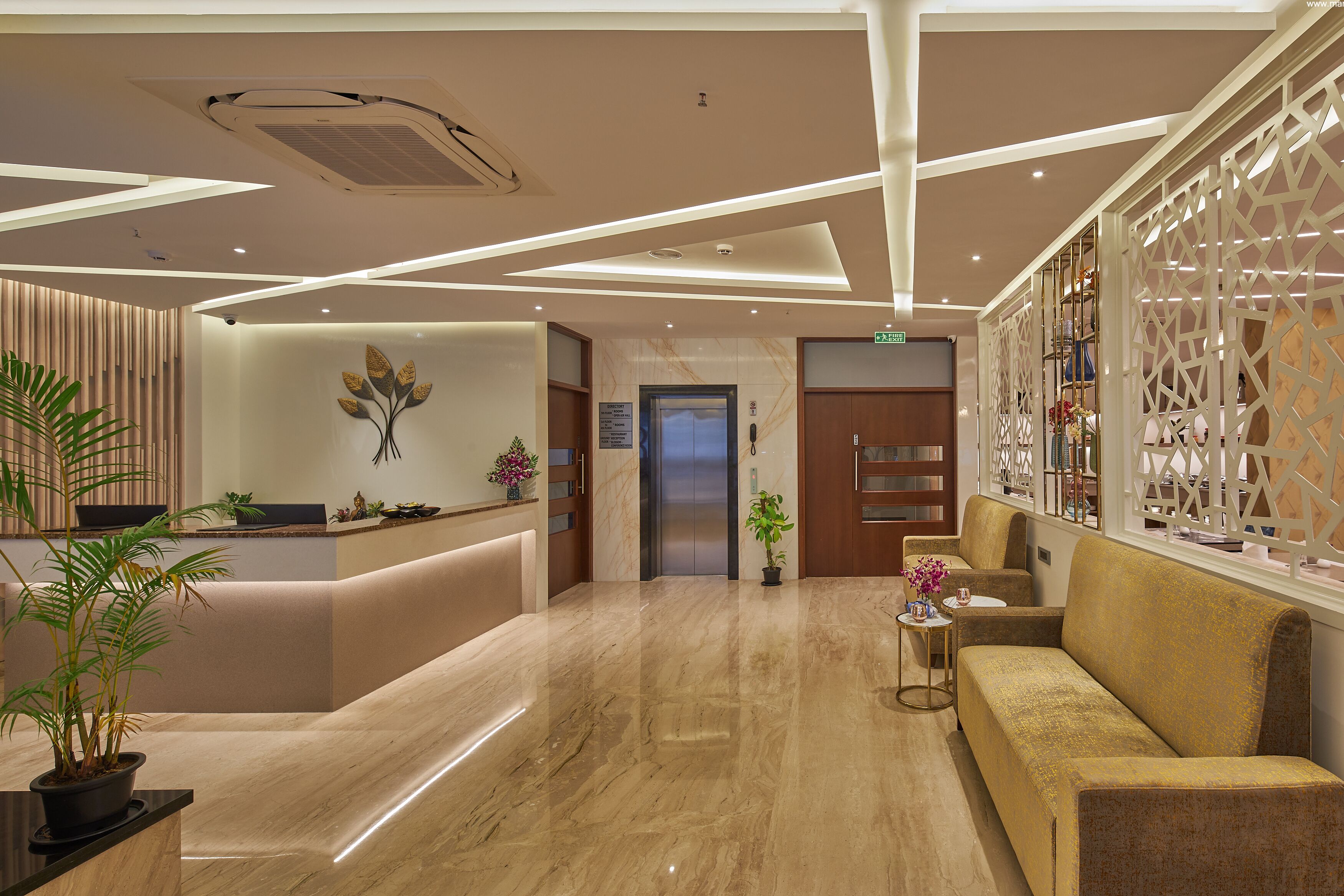 A modern reception area with a marble floor, a reception desk, a sofa, and a decorative wall.