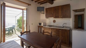 Uma cozinha com armários de madeira, micro-ondas embutido e uma pia.