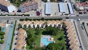 An aerial view of a resort with multiple bungalow-style buildings, a central swimming pool, and a parking area. - Bungalow 2 bedrooms for 5 people with swimming pool in Holiday Park urbanisation (Denia)