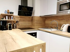 A modern kitchen with a wooden countertop, stainless steel appliances, and a built-in oven.