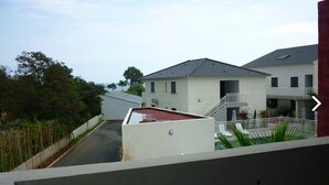 Ein Wohngebäude mit Flachdach, Balkon und kleinem Pool.