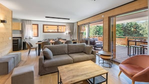 A modern, open-plan living area with a sofa, coffee table, and dining table.