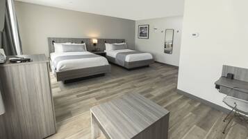 Een moderne hotelkamer met twee bedden, een bureau en een stoel.