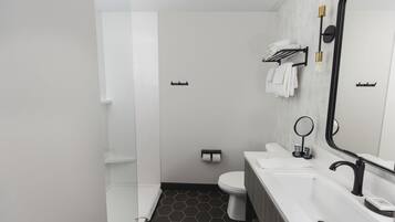 A modern bathroom with a white sink, black faucet, and a large mirror.