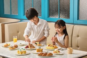 A dining area with a marble table, various breakfast items, and a blue-tinted window view. - Le Méridien Seoul, Myeongdong (Seoul)