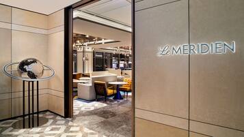 A modern interior with a visible store named 'La Meridien' and a patterned floor.