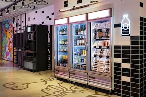 A hotel corridor with vending machines stocked with beverages and snacks.