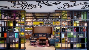 A modern interior with a central seating area, shelves with decorative items, and a patterned rug. - Moxy Seoul Myeongdong (Seoul)