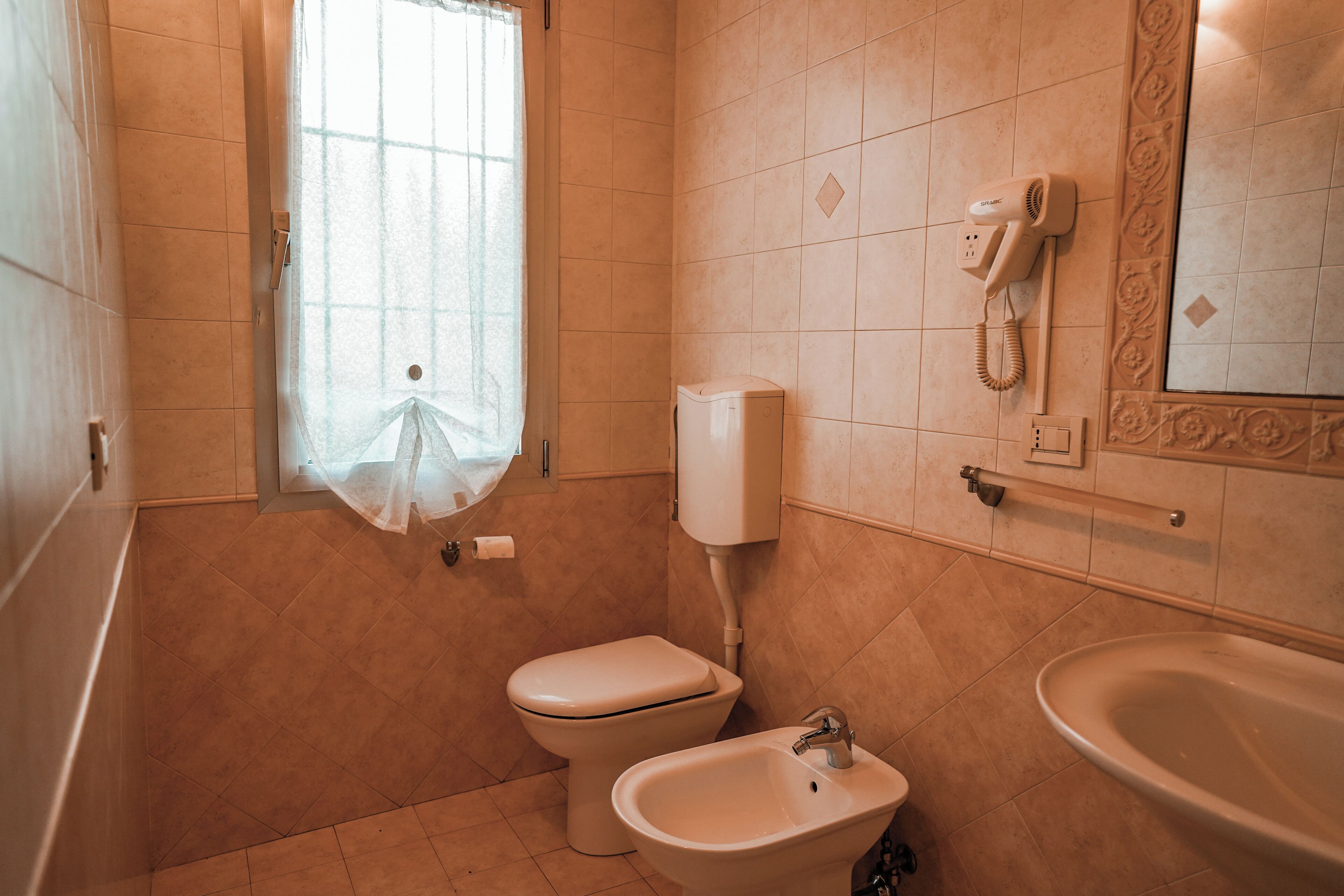 A bathroom with a toilet, bidet, and sink.