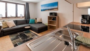 Un salon moderne avec un canapé, une machine à café et une vue sur l’extérieur.