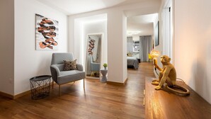 A modern living room with a checkered armchair, a small round table, and a monkey figurine holding a lamp. - Guicciardini Apartment (Florence)