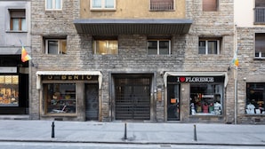 A stone building with storefronts labeled 'UMBERTO' and 'FLORENCE.' - Guicciardini Apartment (Florence)