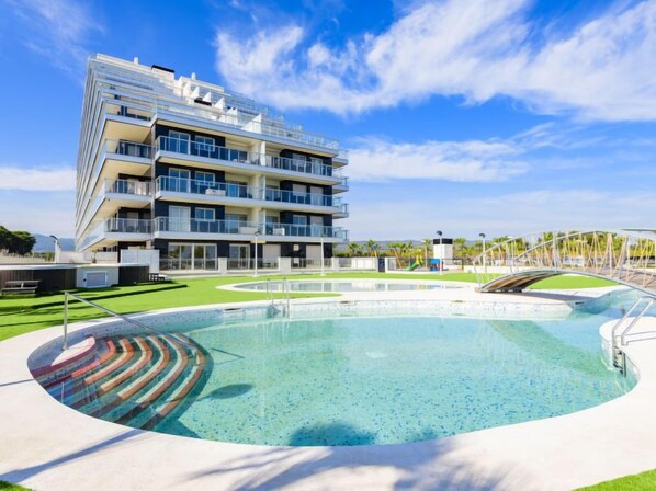 A modern hotel with a large pool, multiple balconies, and a clear blue sky. - Ciudad Jardin by Interhome (Oropesa del Mar)