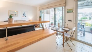 Un apartamento moderno con una mesa de comedor de madera, un balcón con vistas y un ventanal corredero.