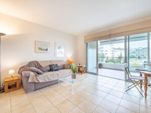 Ein modernes Wohnzimmer mit Sofa, Couchtisch und Balkon mit Blick auf die Stadt.