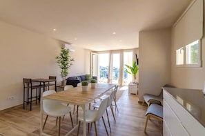 Una cocina moderna con comedor, sofá y un amplio ventanal.