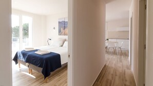 A modern hotel room with a bed, bedside table, and a view of the outside. - Club Villamar - (Lloret de Mar)