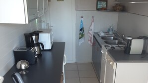 Eine kleine Küche mit Kaffeemaschine, Toaster und Spüle.