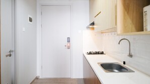 A modern kitchen with white cabinets, a stainless steel sink, and a gas stove.