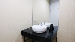 A bathroom with a black countertop, a white sink, and a mirror.