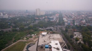 A high-rise building with a rooftop pool and a view of a cityscape.