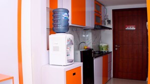 Una cocina con dispensador de agua, cafetera y estufa.