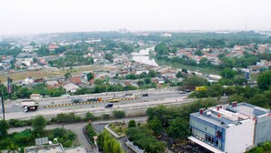 Un paisaje urbano con un río, edificios y una autopista.