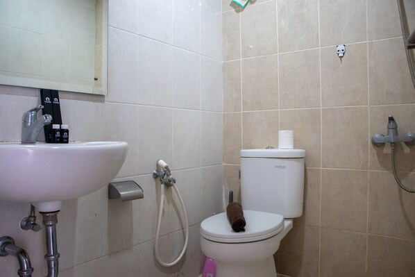 A bathroom with a sink, toilet, and shower.