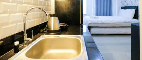 Estudio | Cocina privada | Frigorífico, placa de cocina, utensilios de cocina y mesa de comedor