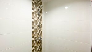 Un baño con azulejos blancos y un diseño a cuadros en la mitad inferior de las paredes.