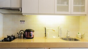 Une cuisine équipée d’une cuisinière, d’une bouilloire et d’un égouttoir à vaisselle.