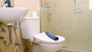 A bathroom with a toilet, sink, and shower. - Comfort Studio At Marina Ancol Apartment (Jakarta)