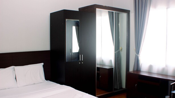 A hotel room with a bed, a wardrobe, a mirror, and a desk. - Comfort Studio At Marina Ancol Apartment (Jakarta)
