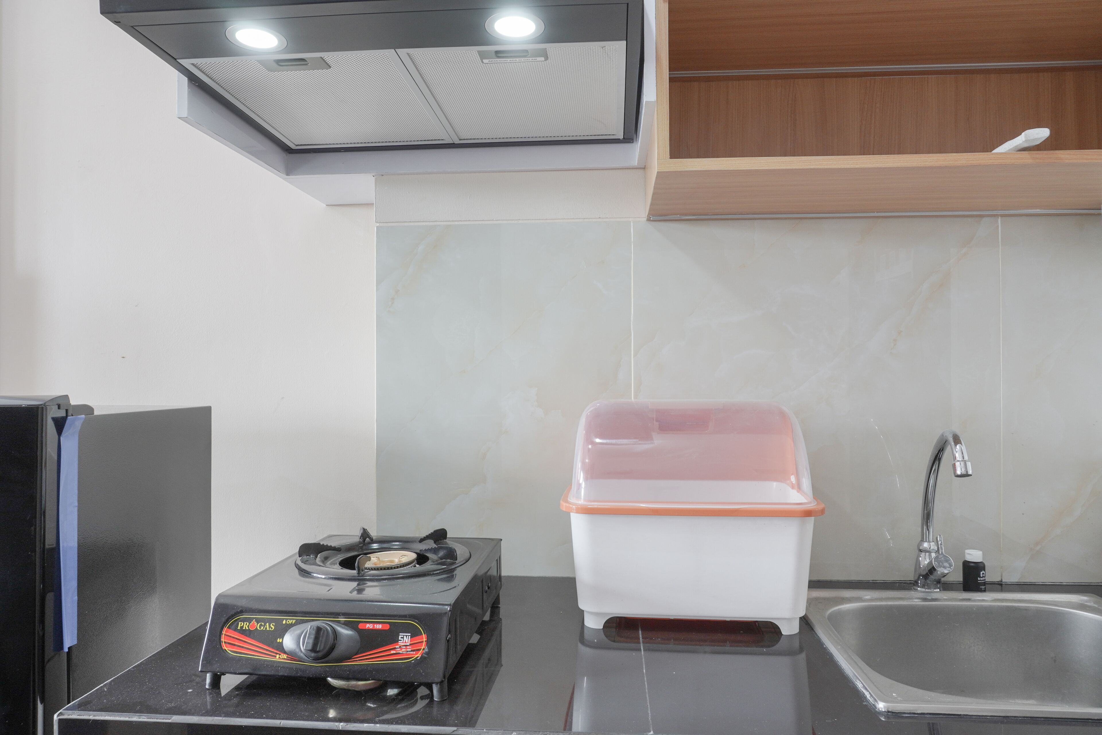 A kitchen with a gas stove, a sink, and a cabinet.