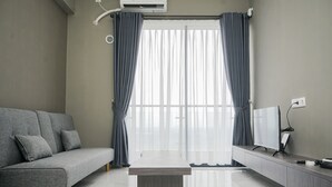 Ein modernes Wohnzimmer mit einem grauen Sofa, einem Flachbildfernseher und einem eleganten Couchtisch.