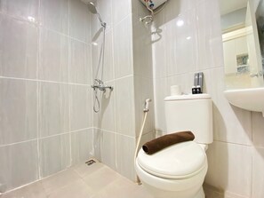 A bathroom with a shower, toilet, and sink. - Comfy Studio Room At Grand Asia Afrika Apartment (Bandung)