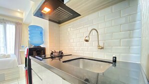 Eine moderne Küche mit schwarzem Arbeitsplatz, weiß gefliestem Fliesenspiegel und einer Spüle aus Edelstahl.
